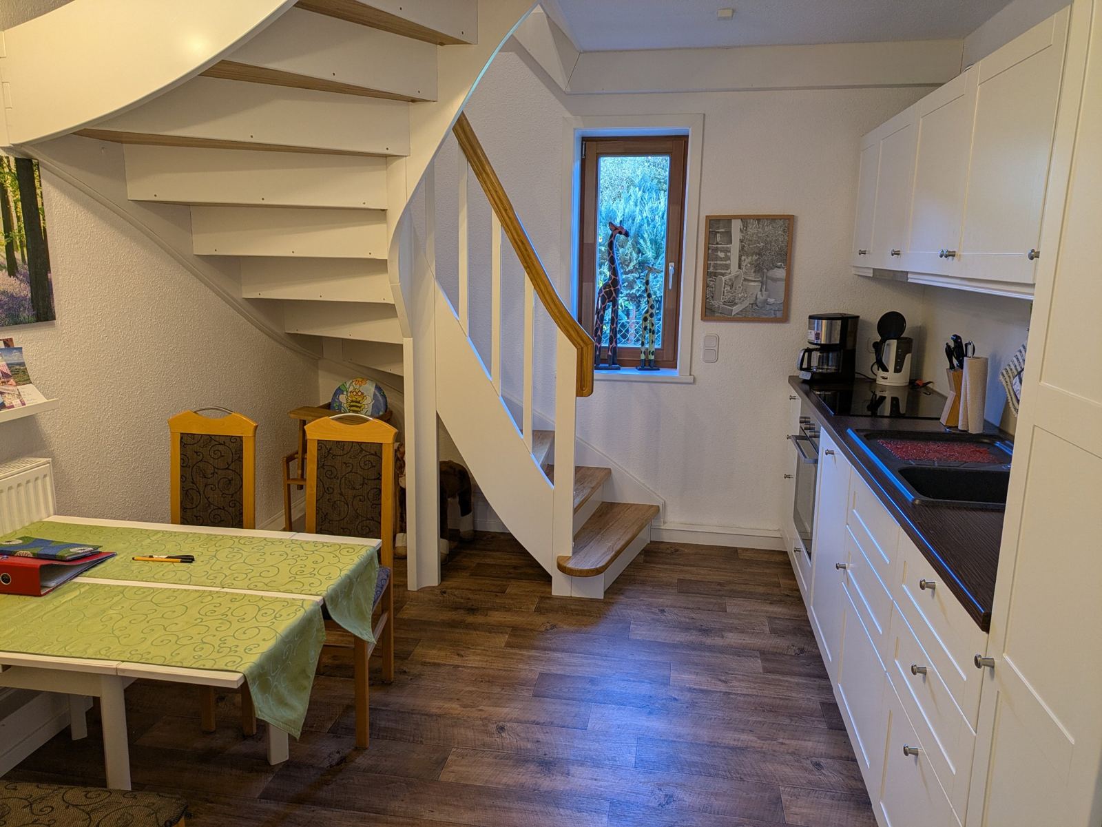 Essplatz und Küche mit Holztreppe ins Obergeschoss