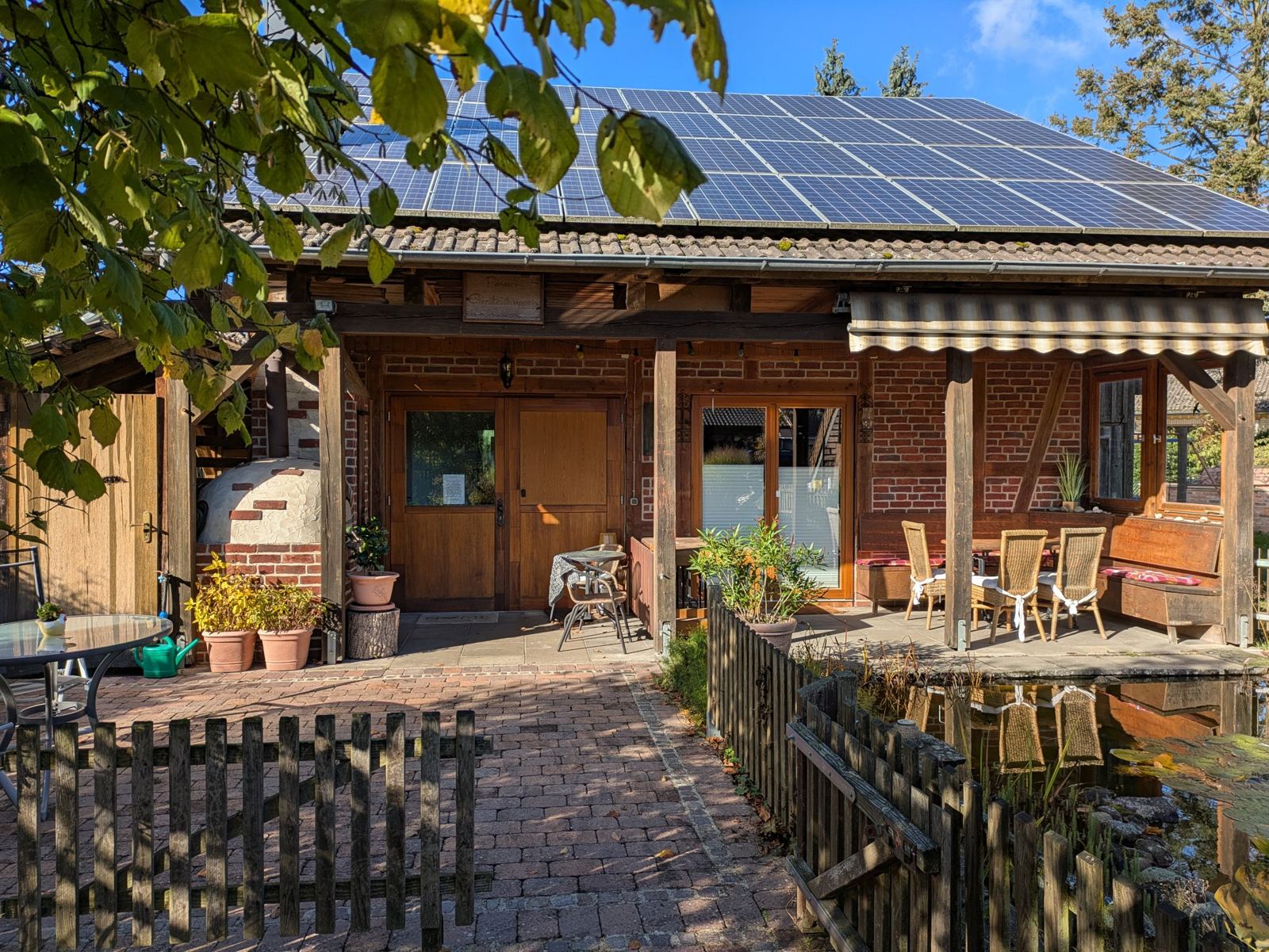 Überdachte Terrasse mit Sitzplätzen am Teich